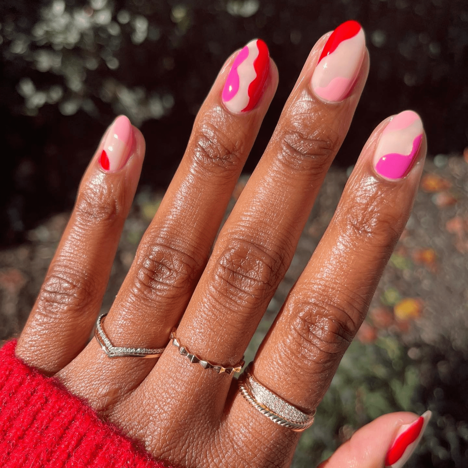 pink and red wavy nail design with negative space