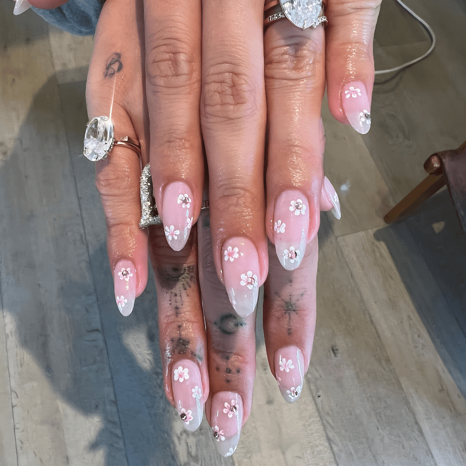 hailey bieber's hands with cherry blossom manicure