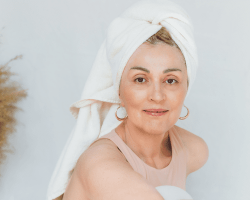 Close up of a woman with her hair wrapped in a towel and smooth skin