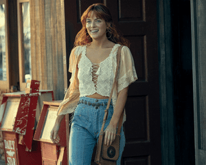 Riley Keough in Daisy Jones and the Six Wearing white peasant top