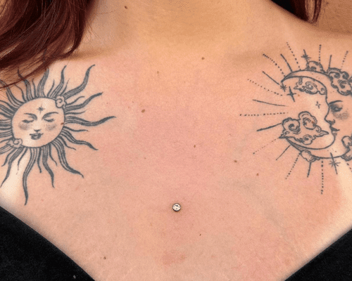 A woman's chest with tattoos on each clavicle and a dermal piercing in the center of the chest