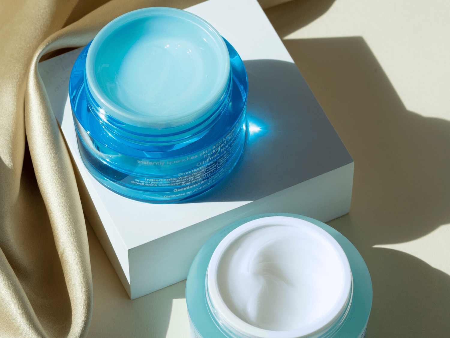  Two blue jars of facial cream.