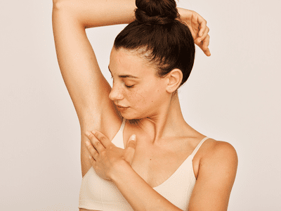 A woman with her arm up as she touched her underarm