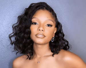 Halle Bailey wearing a side part hairstyle.