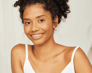 A woman with her hair pulled back and clear, glowing skin