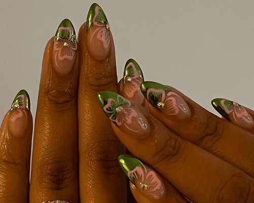 Close up of a green chrome French manicure with baby pink hibiscus nail art.