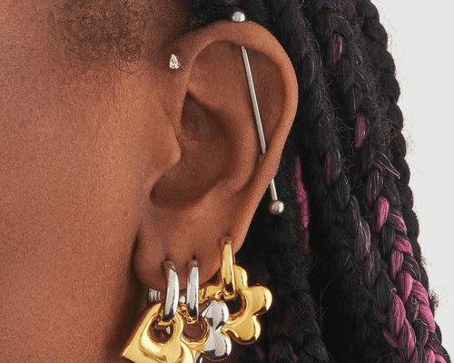 Close up of an ear with an industrial bar piercing