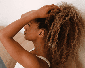 Close up of woman touching her curly hair