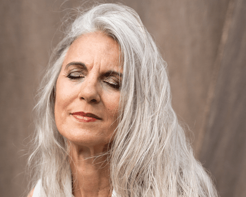 woman with gray hair against tan background