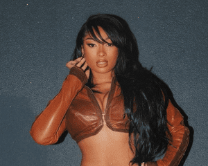 Megan Thee Stallion with side bangs wearing a brown leather top