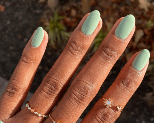 A close up of mint sage green nails.