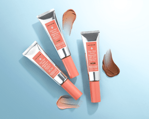 Naturium Dew Glow Tinted Moisturizers on a blue background