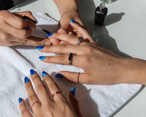 woman painting a client's nails