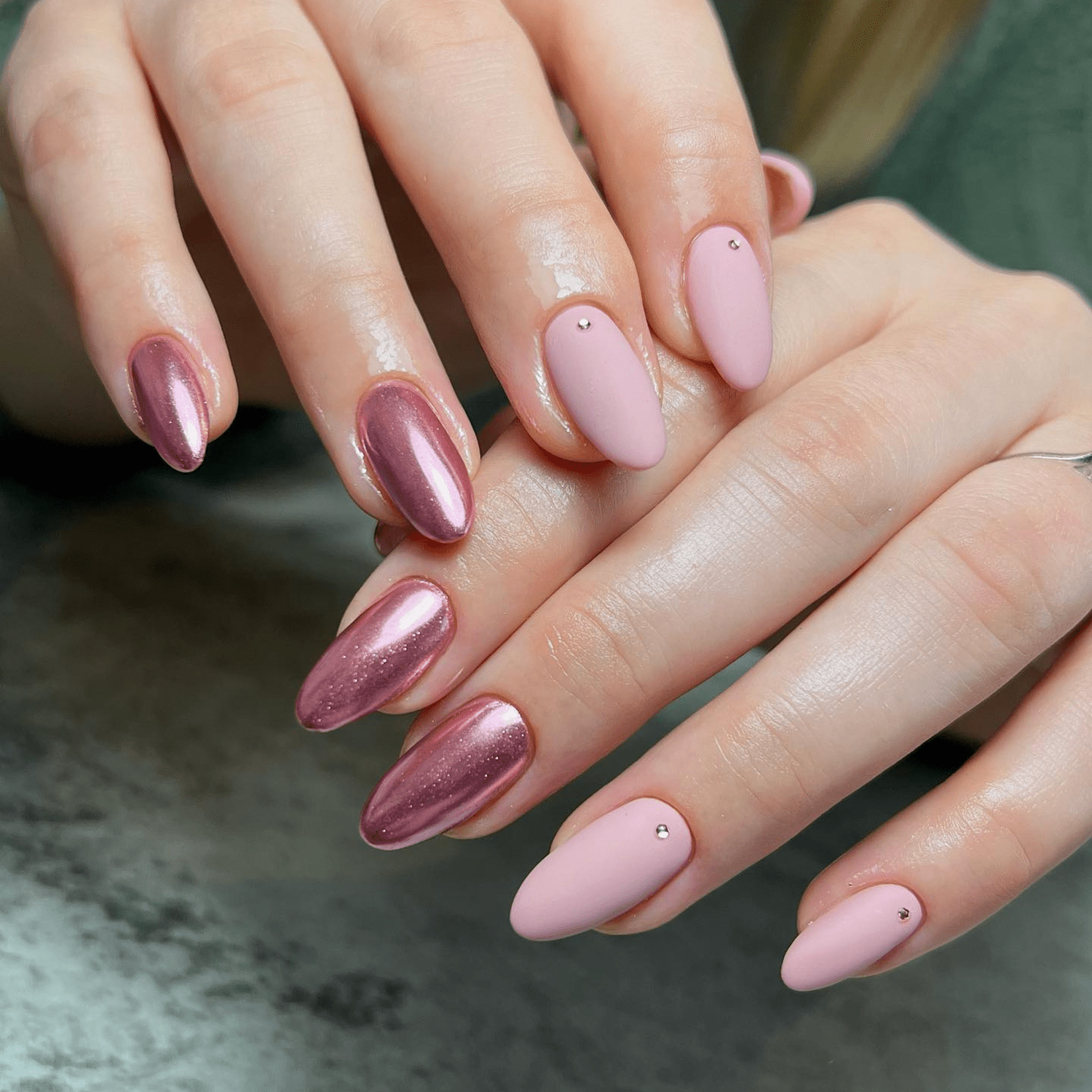 Rose gold chrome and pale pink manicure with small jewel accents.