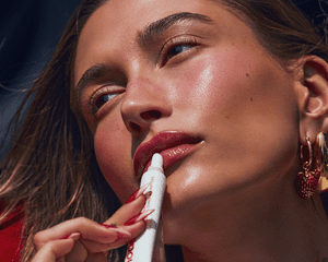 Hailey Bieber applying the new Rhode Strawberry Glaze Peptide Lip Treatment