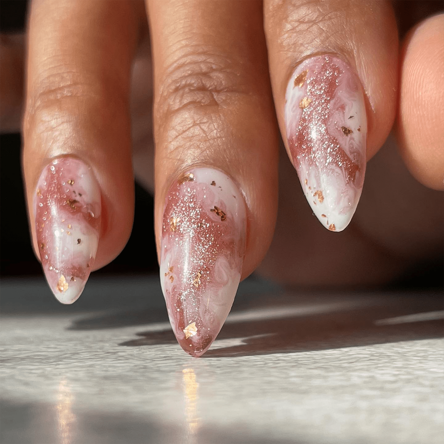 Rose gold galaxy inspired nails with specks of gold and white