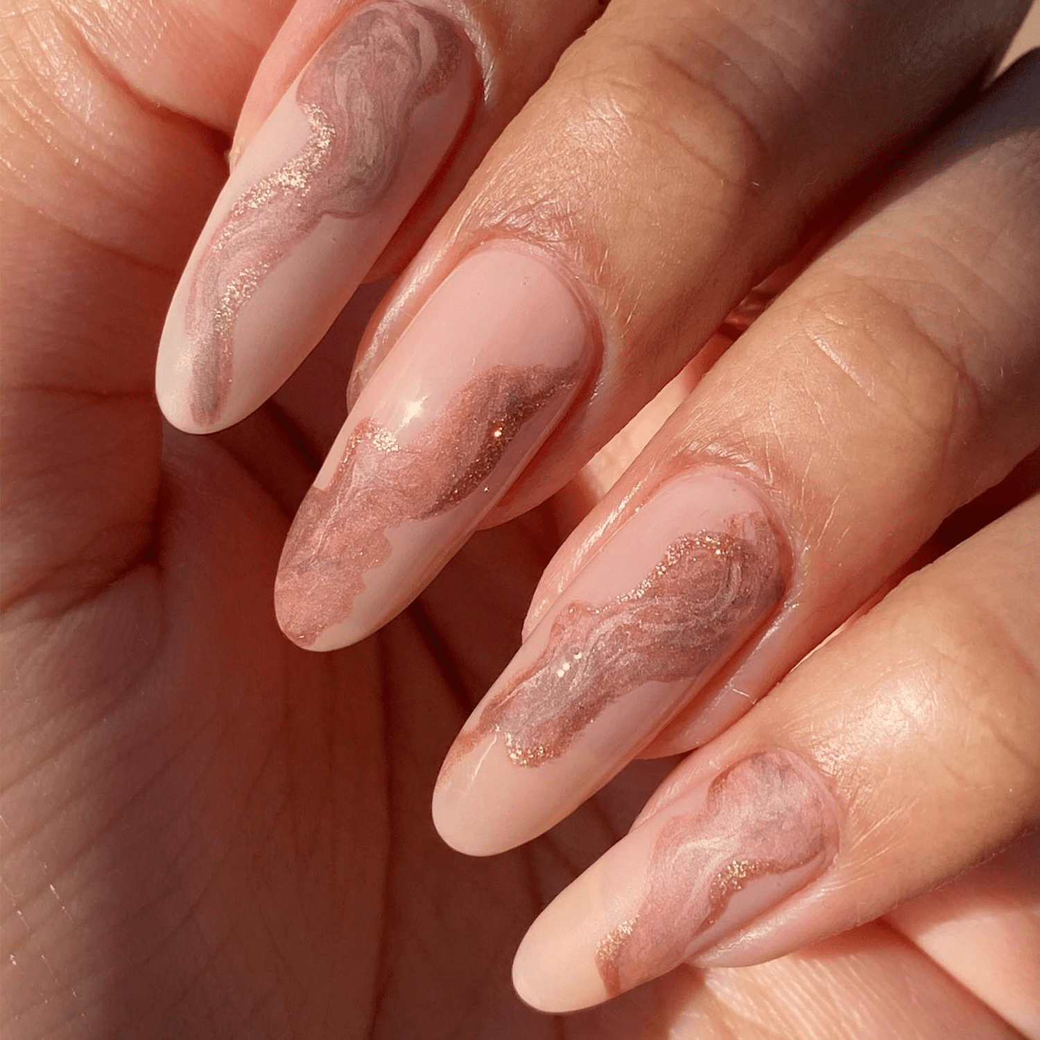 Pink nails with rose gold marble swirls