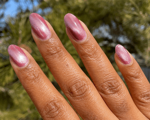 Hand with a diamond ring with rose chrome nails