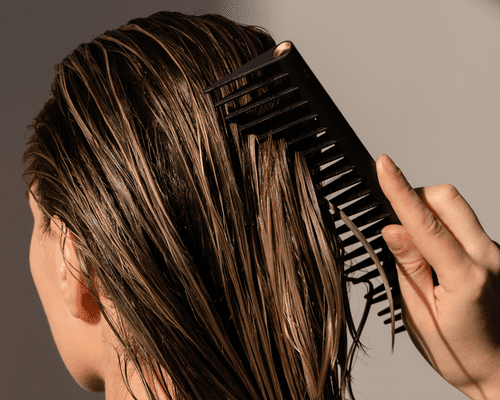 woman running comb through wet hair