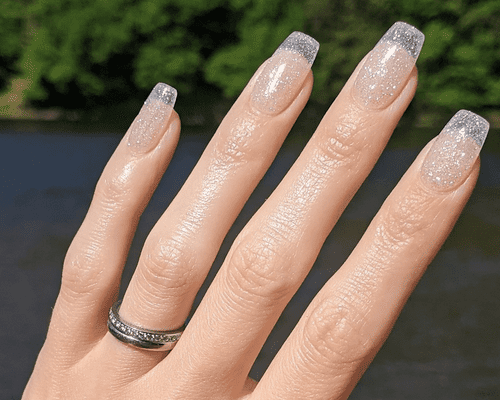 A clear and glittery dip powder manicure