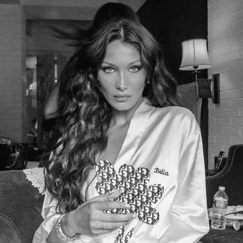 Bella Hadid wears long, wavy hair and a silk robe