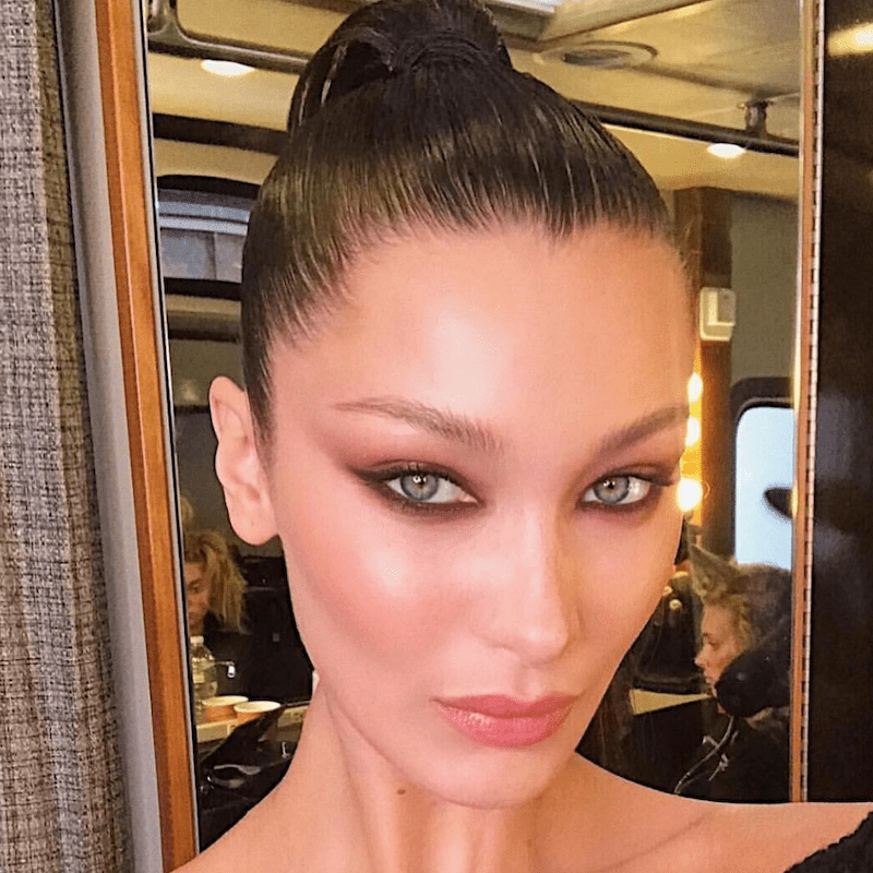 Bella Hadid wears a slicked-back ponytail and smoky eye