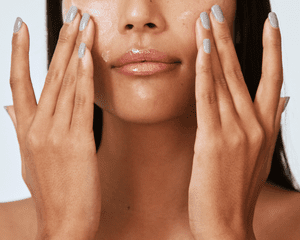 Close up of a woman applying moisturizer to her face