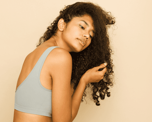 Image of woman touching her curly hair