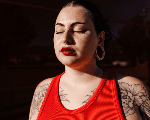 woman with red lipstick and flower tattoos